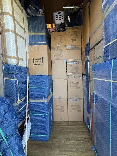 Boxes and blanket-wrapped furniture carefully loaded in a truck