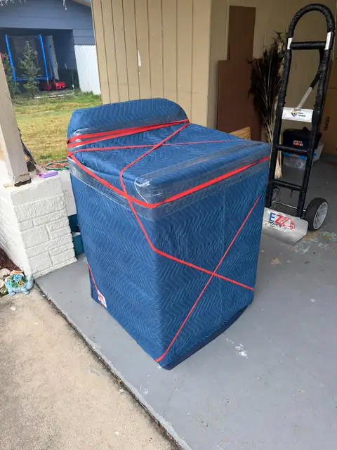 Appliance protected with moving blankets, wrap and straps